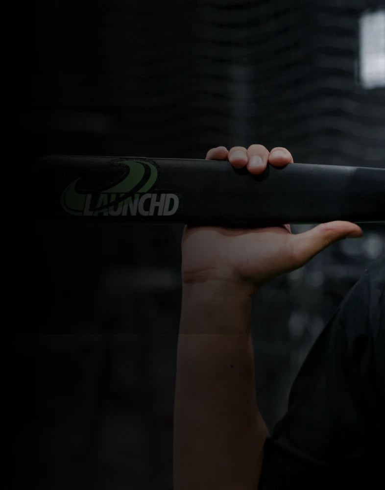 Hand holding a black object with 'Launchd' branding against a dark background