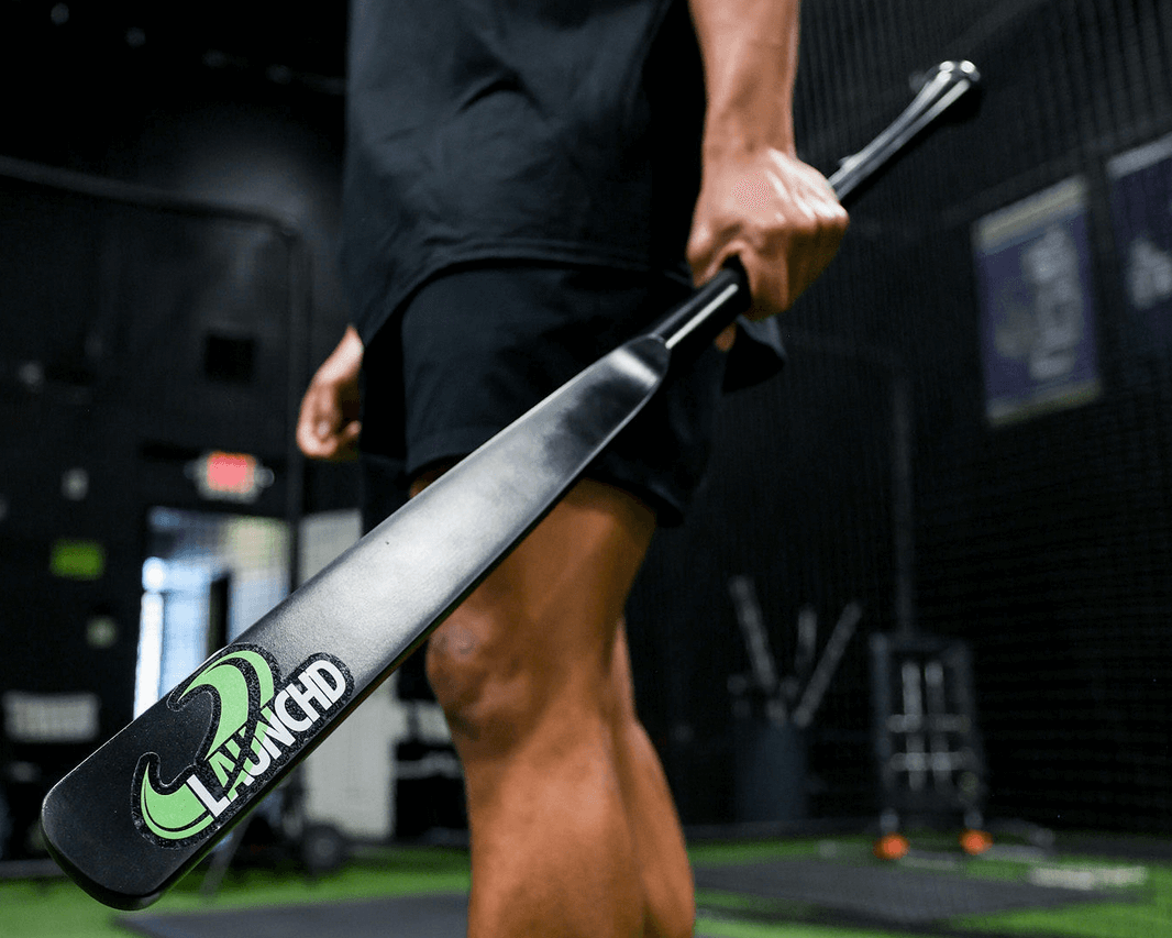 Person holding a baseball bat with a brand logo on a sports field