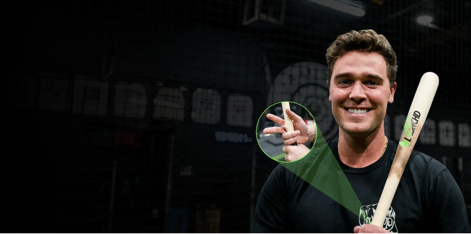 Man holding a baseball bat with a close-up of his hand on a dark background